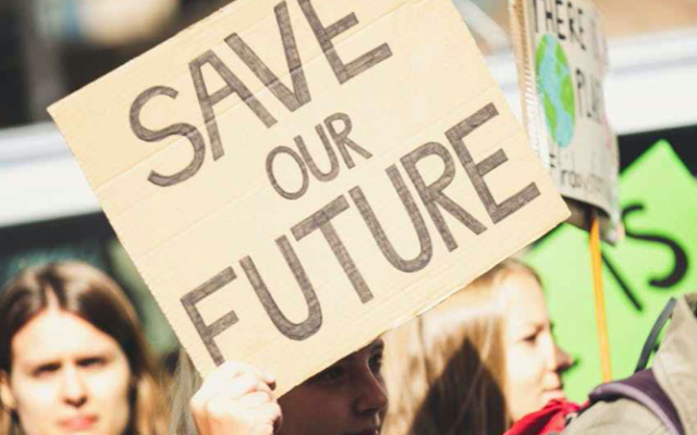 Crowd of protesters woman holding sign that reads Save our Future