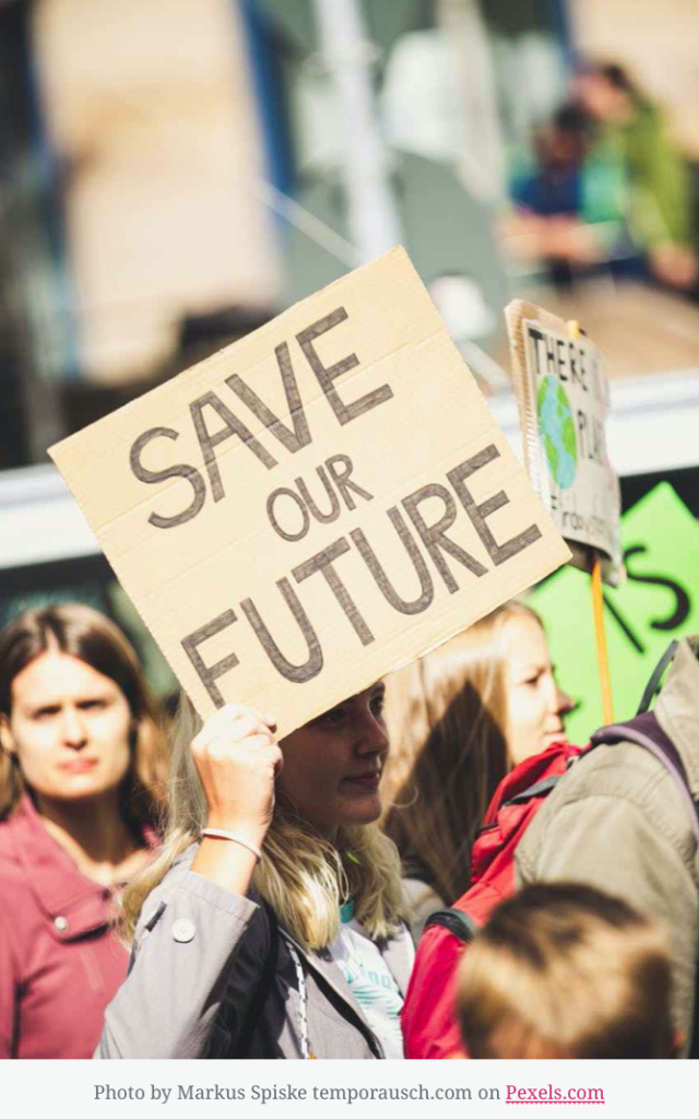 Crowd of protesters woman holding sign that reads Save our Future