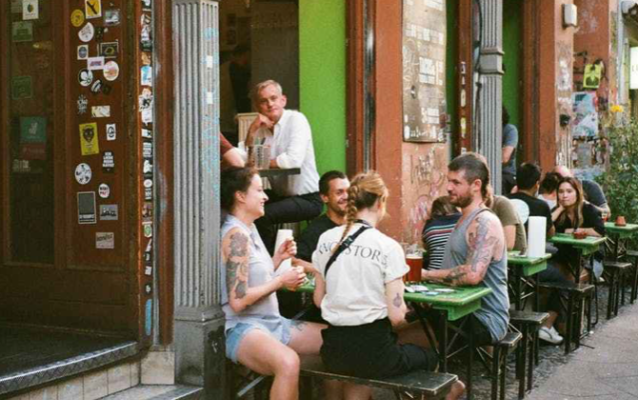 Sidewalk cafe a group gathered around is talking