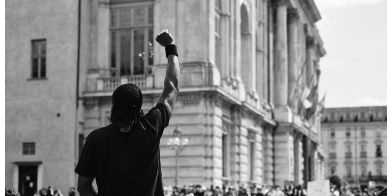 Person with a raised fist at a rally
