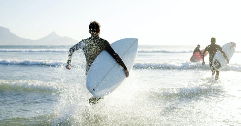 Surfers running out to the waves